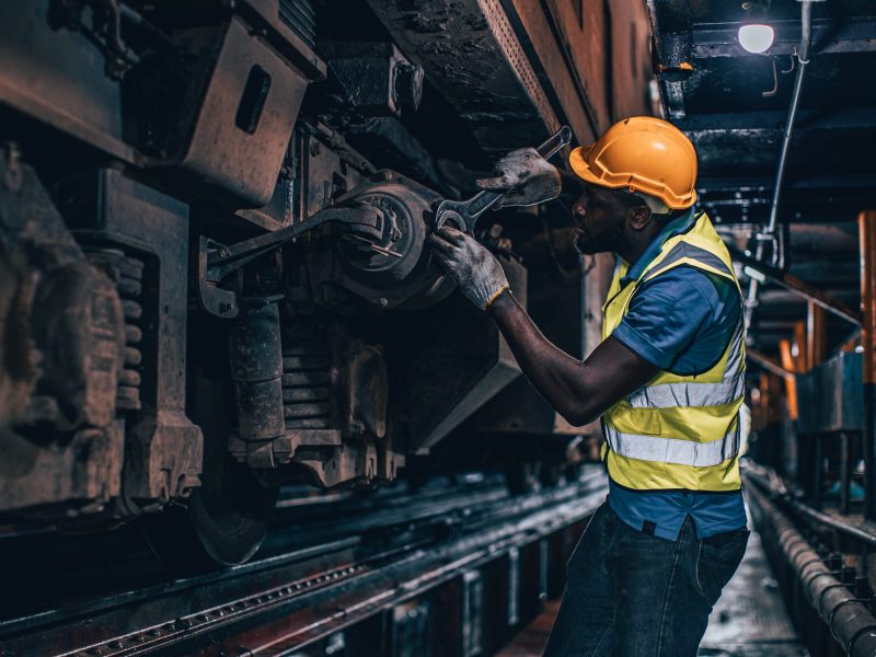 one man worker servicing replace broken part of old train at diesel locomotive repair shops via Getty Images