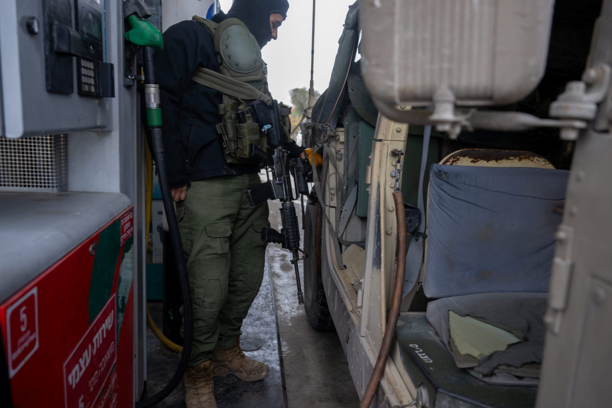 An IDF soldier fills a hummer with petrol at a petrol station near the Gaza border on November 19, 2023 in Southern Israel. Photo by Alexi J. Rosenfeld/Getty Images