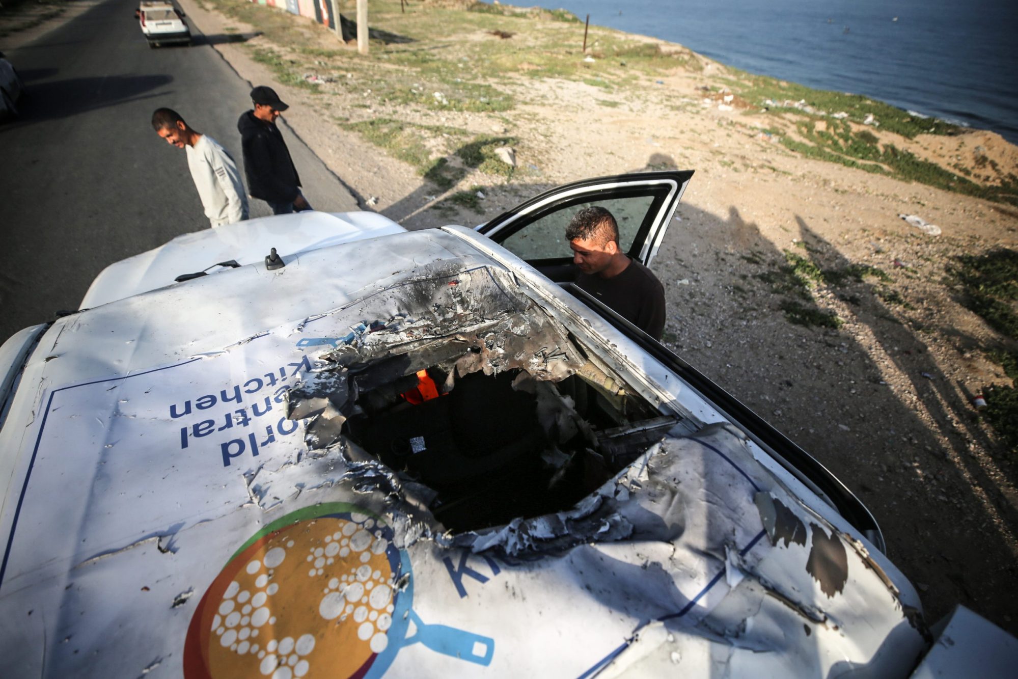 Palestinians are standing next to a vehicle in Deir Al-Balah, in the central Gaza Strip, on April 2, 2024, where employees from the World Central Kitchen, including foreigners, were killed in an Israeli airstrike, according to the NGO. Photo by Majdi Fathi/NurPhoto via Getty Images